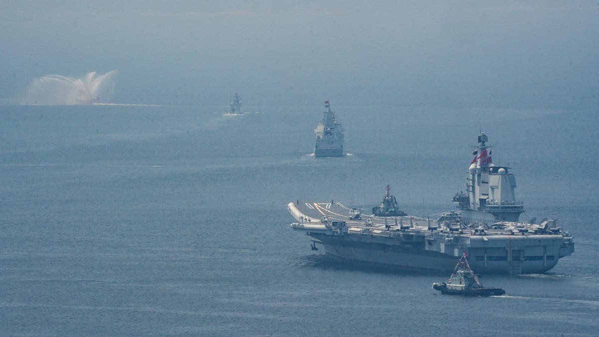 The Chinese aircraft company leads a formation of marine vessels during marine operations, with visual support ships in the distance under a fog sky.