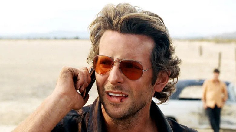The Hangoper, Bradley Cooper in Phil, talks on the phone on a bloody lip