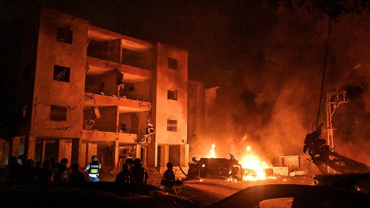 Firefighters and saving personal work on the impact site after a missile attack from Iran on Israel, in Haifa, Israel, June 15, 2025.
