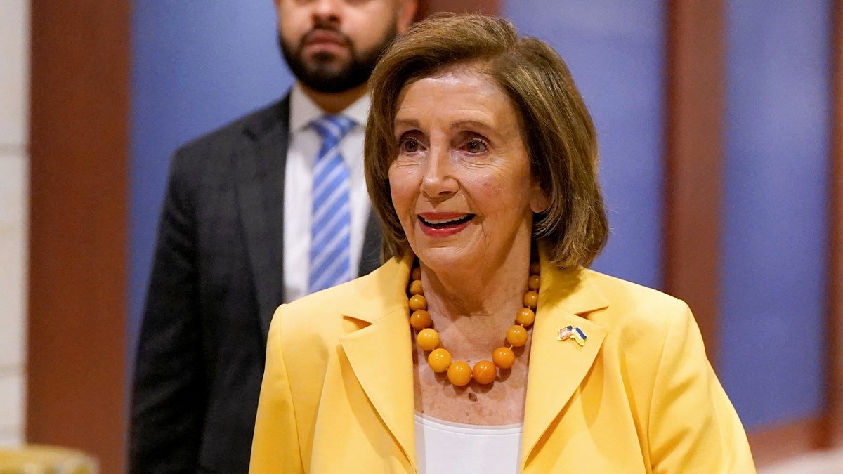 Representative Nancy Pelosi wears a yellow jacket