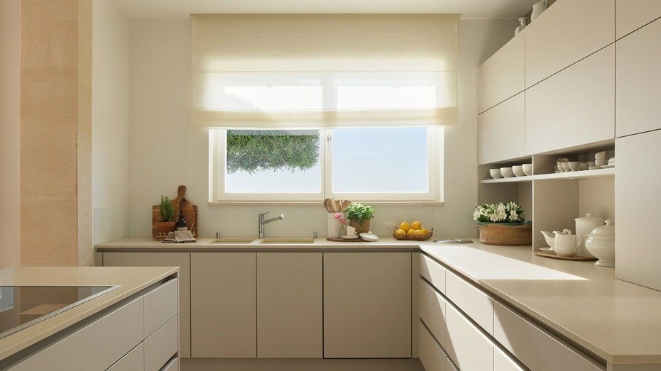 The elegant kitchen features white cabinets and surfaces.