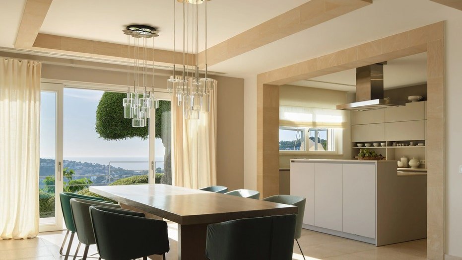 A kitchen for open floors with the dining table located near it.