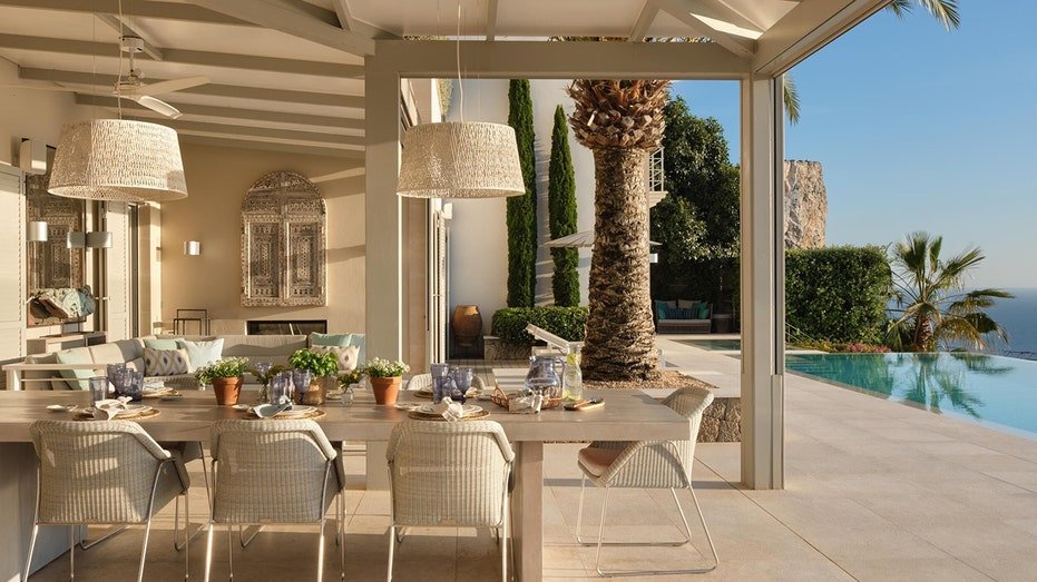 The backyard is characterized by an outdoor dining area with an outdoor fireplace.
