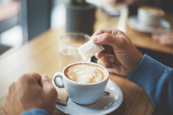 The man puts sugar in coffee Sugar alcohol