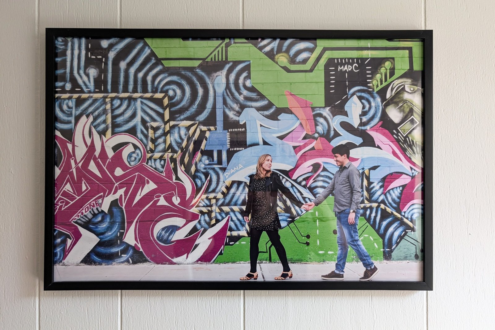 A sticker appears a wall on the walls with two people in front of him walking side by side.