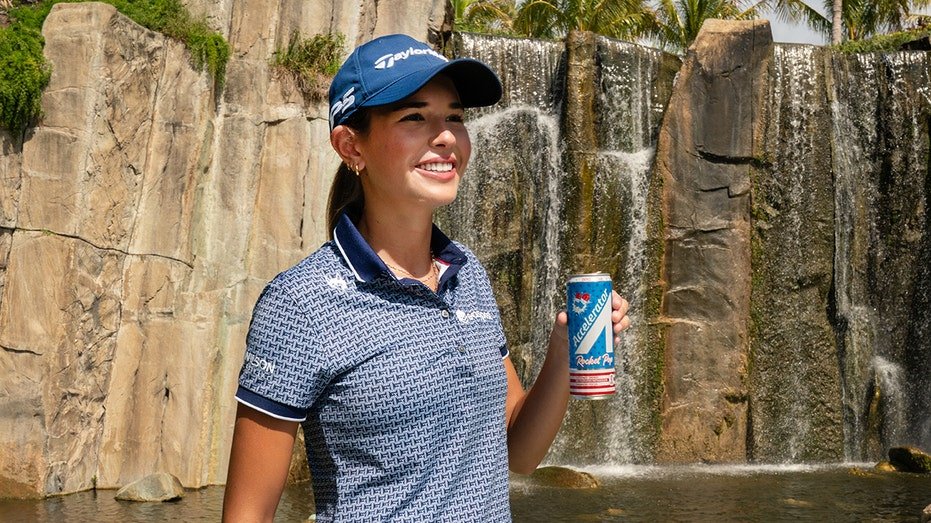 Kai Trump smiles with a faster drink