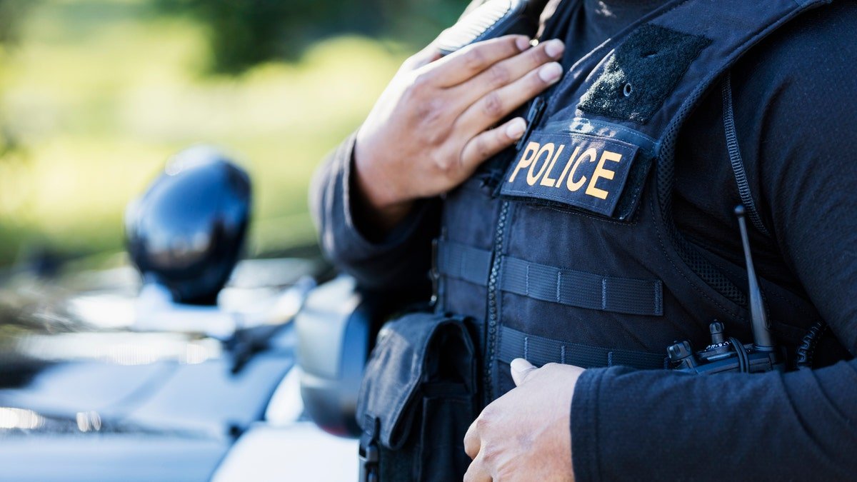 A policeman in the uniform, close to a jacket
