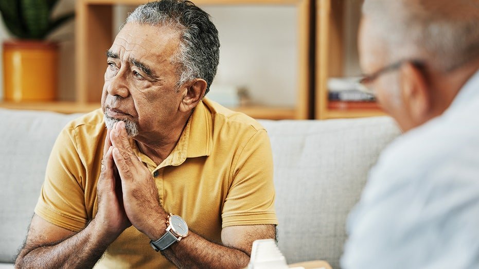 An elderly man speaks to a psychological world in the mental health clinic, psychology and treatment of the session. The psychotherapist with the portfolio to consult the review list with the senior male patient in his position