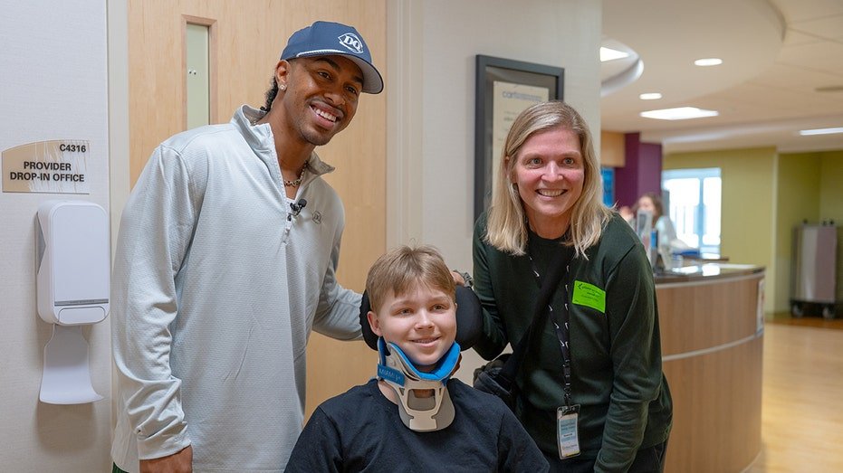 Francisco Lindor smiles with a baby hospital patient
