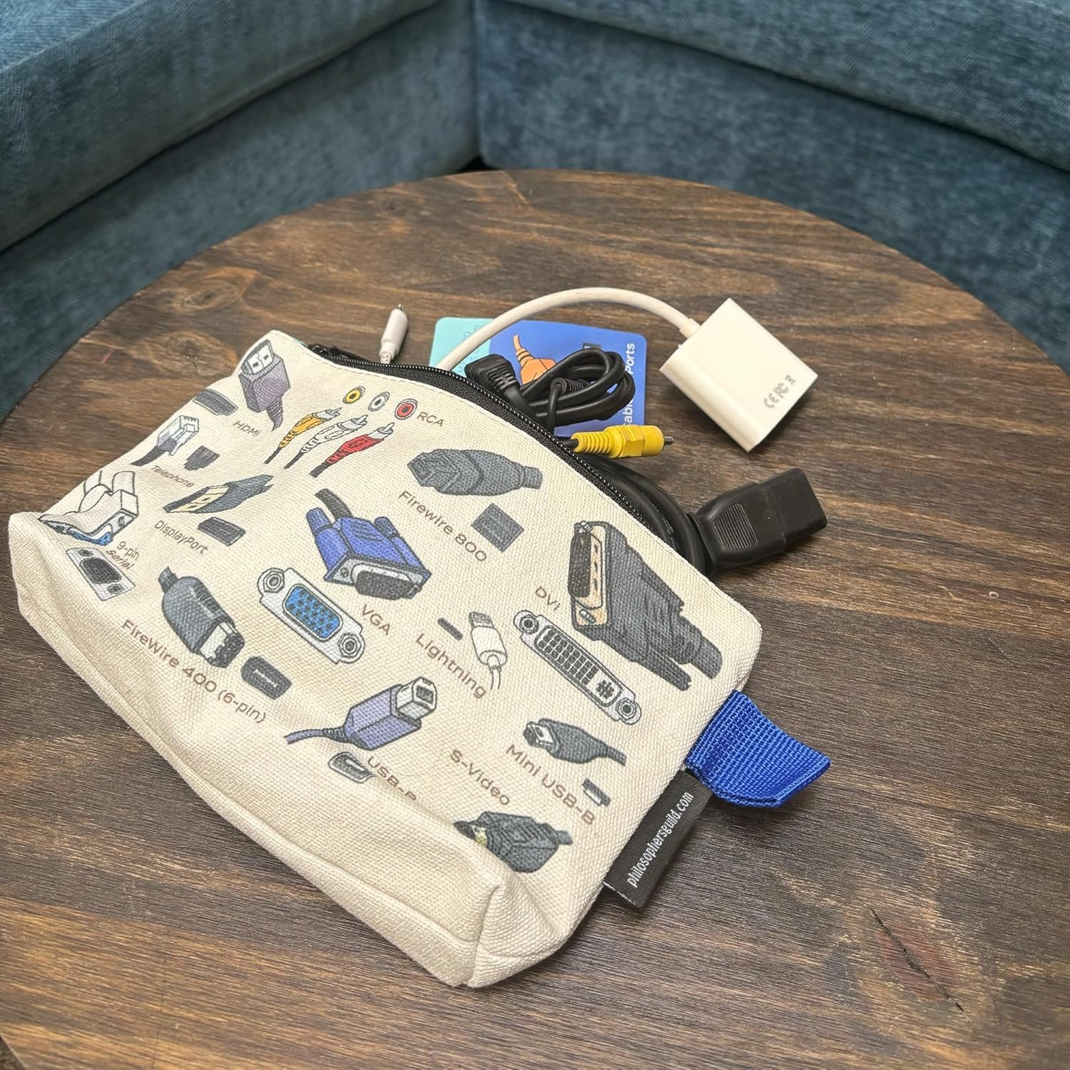 Zipper bag with printed images of tech, opened to reveal various cables and other small items.