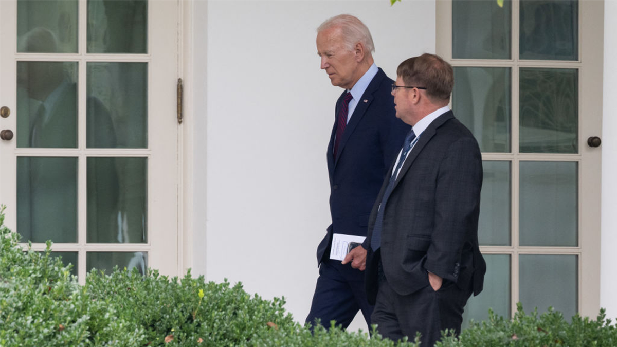 President Joe Biden talks to White House doctor Kevin Occor