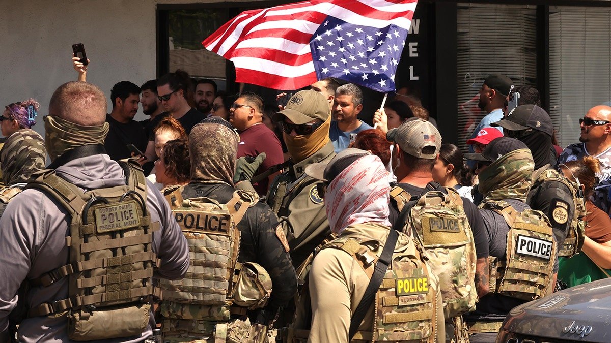 Demonstrators face ice agents during the California Migration Randing
