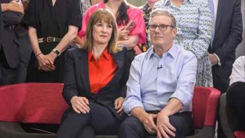 Rachel Reeves is sitting next to Care Starmer on a red sofa