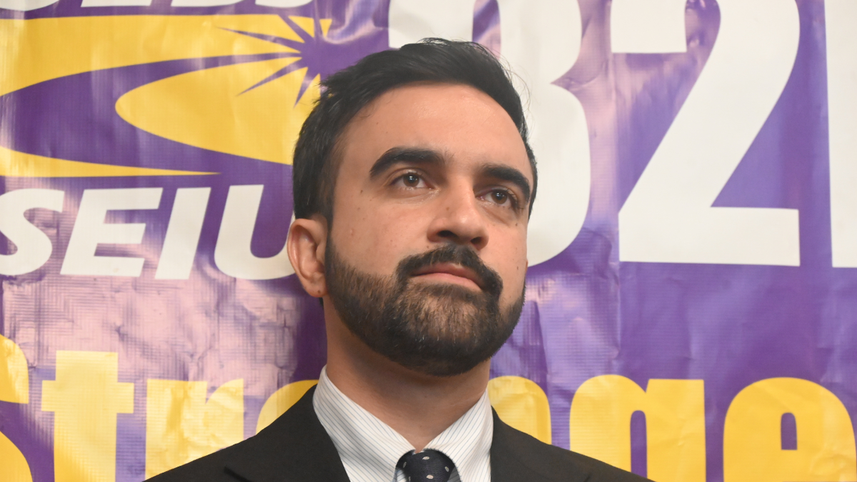 Mamdani, who is close to the Seo banner behind him