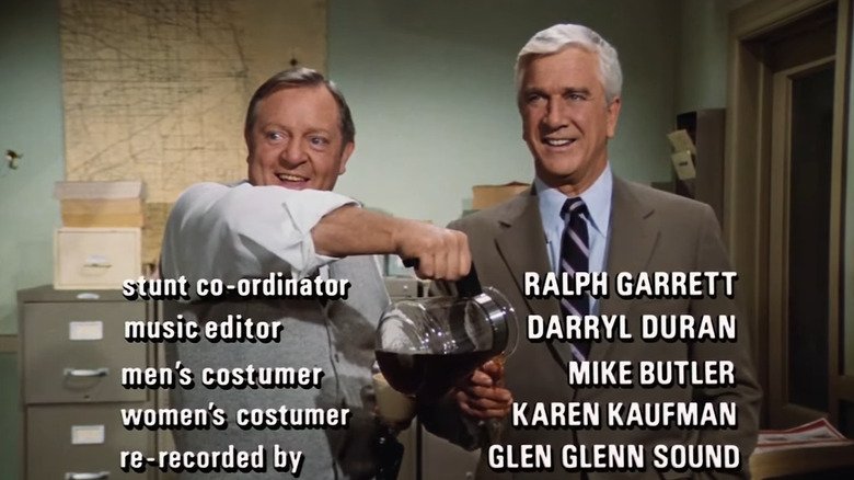 Ed Hawkin (Alan North) pour coffee at the hands of Frank Darbin (Leslie Nielsen) while freezing it in the police squad