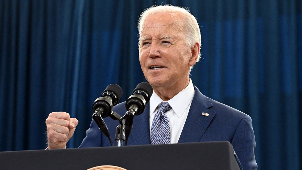 Joe Biden speaks on the platform, and makes a fist