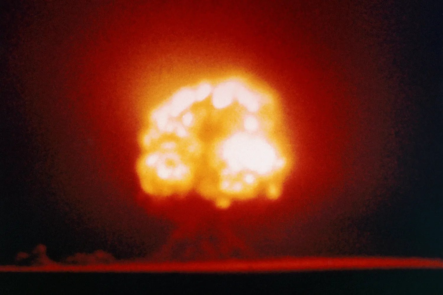 The giant orange mushroom cloud on the horizon explodes during the first atomic test in New Mexico on July 16, 1945.