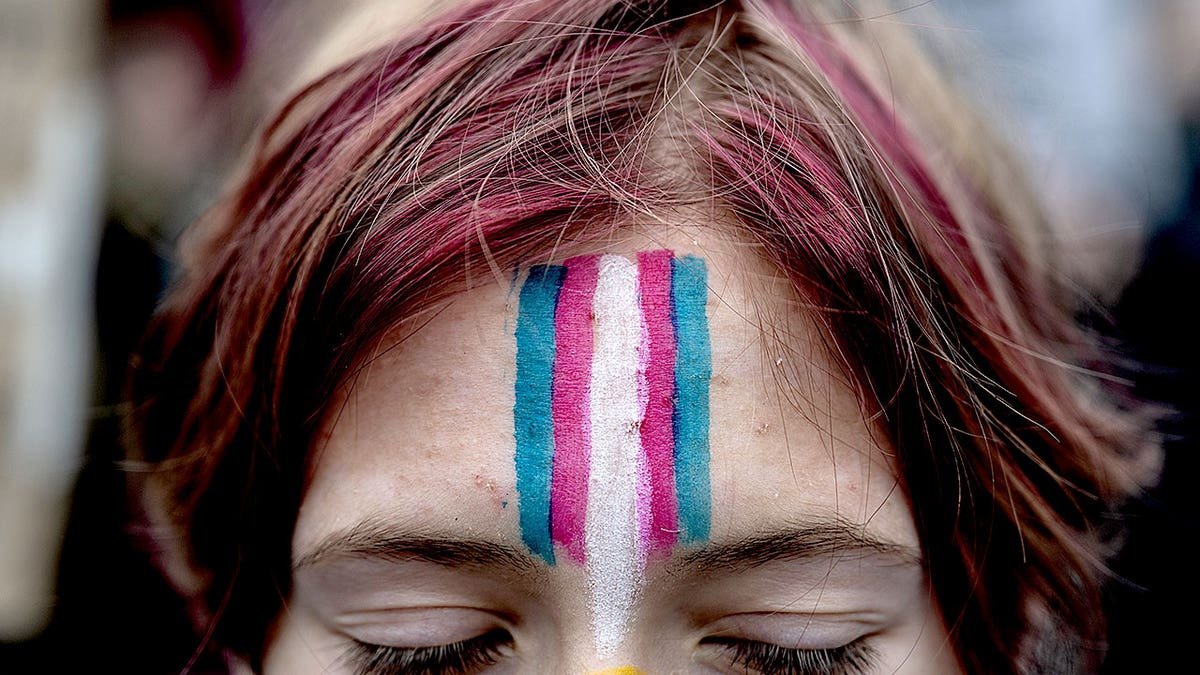 A young man with transgender people drawn on the face