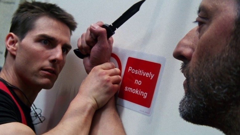 Ethan Hunt holds Crager from the wrist while holding a knife in the mission: impossible