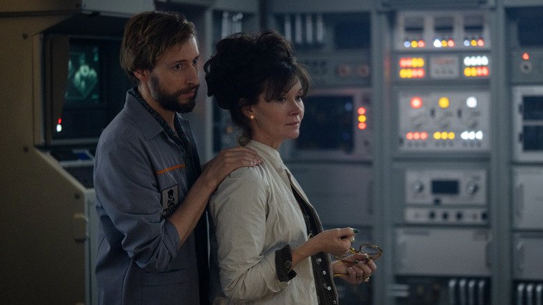 Arthur and Silvia hold each other in the miracle laboratory in the foreigner: Earth