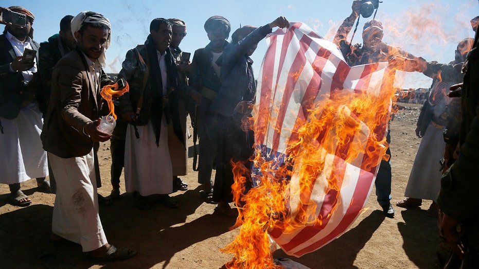 Houthi followers burn American and Israeli flags