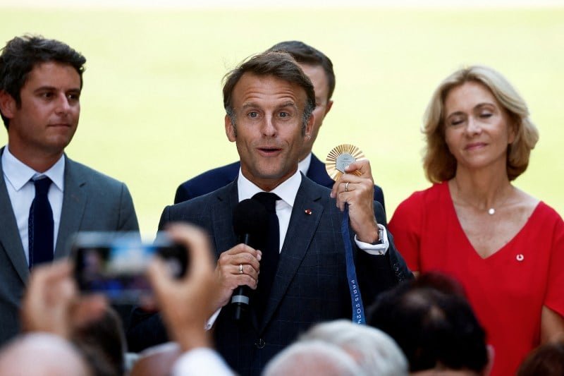 French President Emmanuel Macron holds an Olympic gold medal as he delivers a speech to representatives of stakeholders who helped organize and host the 2024 Paris Olympic Games, seen at the Élysée Palace in Paris on Aug. 12.
