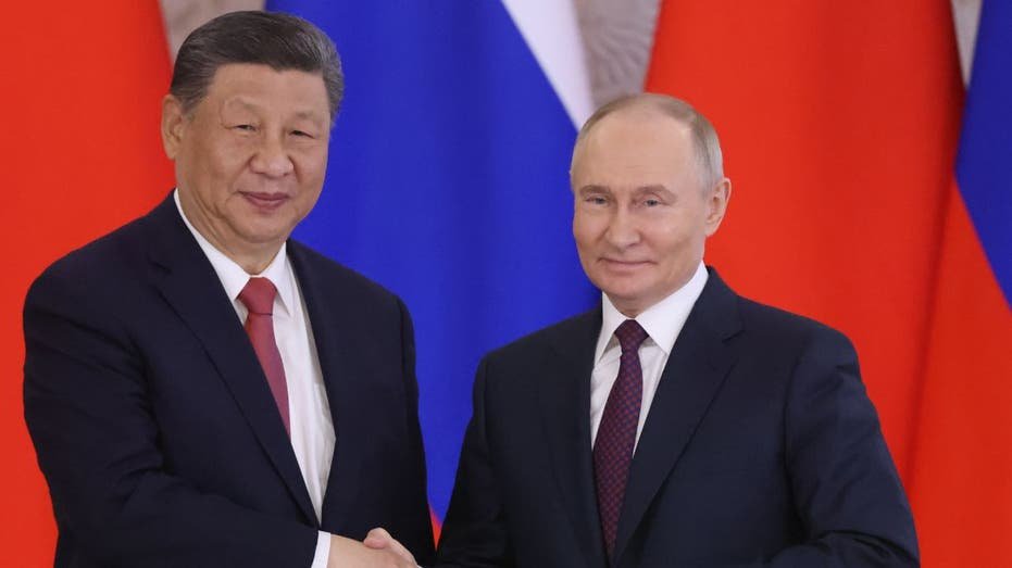 Russian President Vladimir Putin shakes hands with Chinese President Xi Jinping