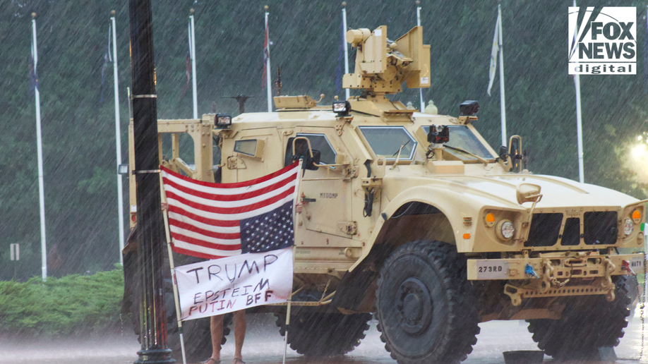 The protest stands in the rain to protest against the National Guard