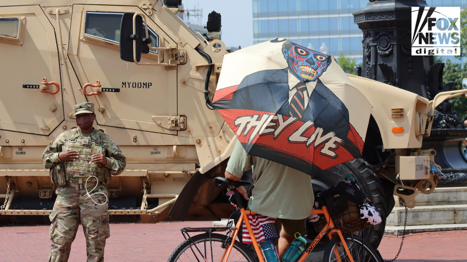 The protester stands with the National Guard