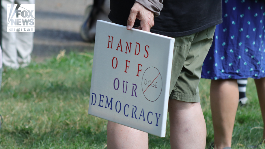 A protester holding marks to defend democracy