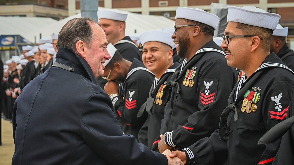 Secretary Villan shakes his hands sailor