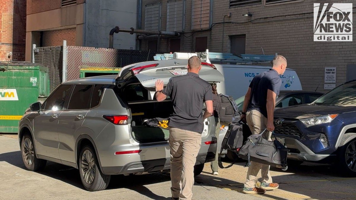 FBI agents download bags in a vehicle after searching for the John Bolton office in the capital, August 22, 2025.