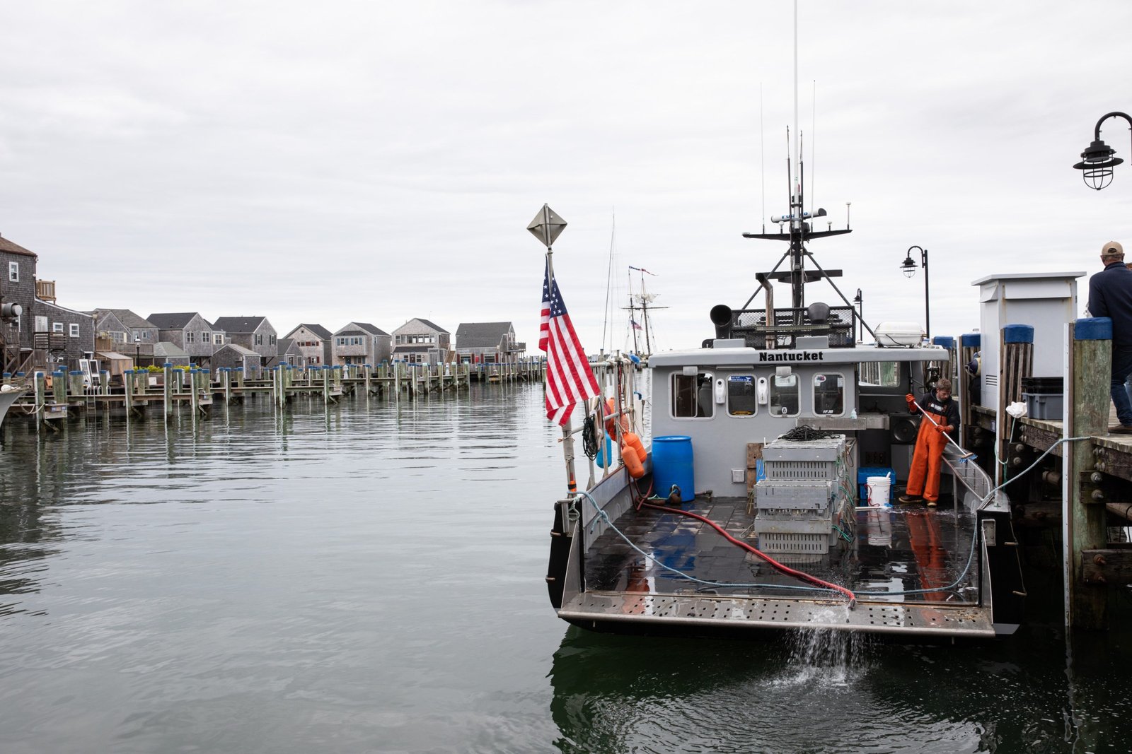 Brooks Robbie cleans the Black Earl commercial fishing boat after he and captain Dan Pronk returned from fishing for whelk. Nantucket, Massachusetts, May 19th, 2025.