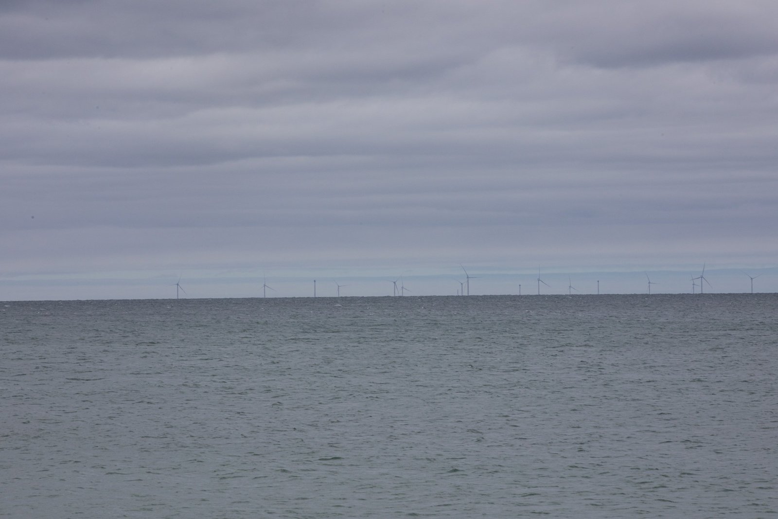 On an overcast day, wind turbines can be seen on the horizon from Madaket Beach on the south shore of Nantucket. This cluster of 62 turbines 15 nautical miles from Nantucket is operated by Vineyard Wind. May 20th, 2025.Many people are opposed to the turbines, especially after an accident on July 13th, 2024, where a 115,000-pound blade from a Vineyard Wind turbine malfunctioned and broke off, creating massive amounts of debris.