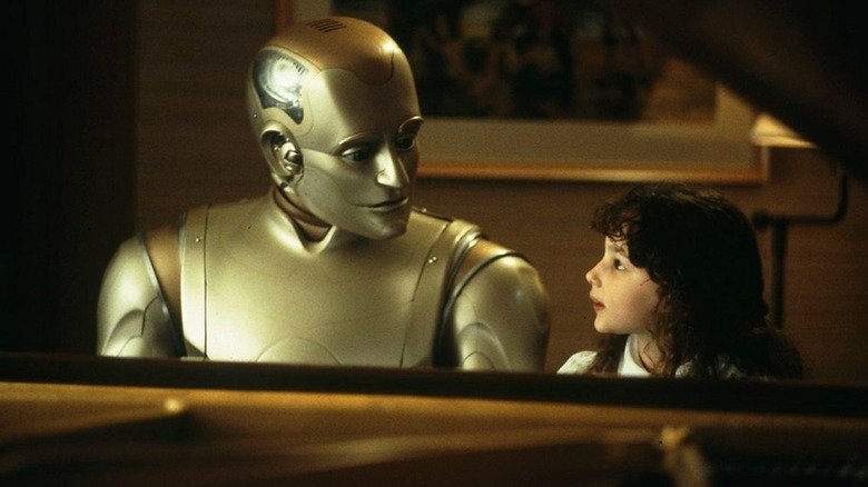 Andrew (Robin Williams), elegant metal robot, and Little Miss (Halle Eceenberg) sits on a large piano in a warm room, their faces turned together with strange expressions in Mentinal.