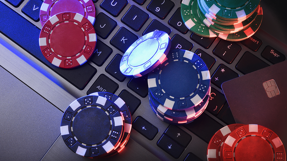 The concept of online online betting with chips on the laptop keyboard and a bank card. Top view.