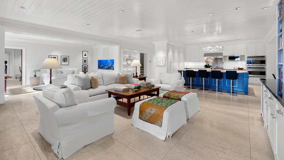 The house features a second sitting room with all white furniture and light solid floors.