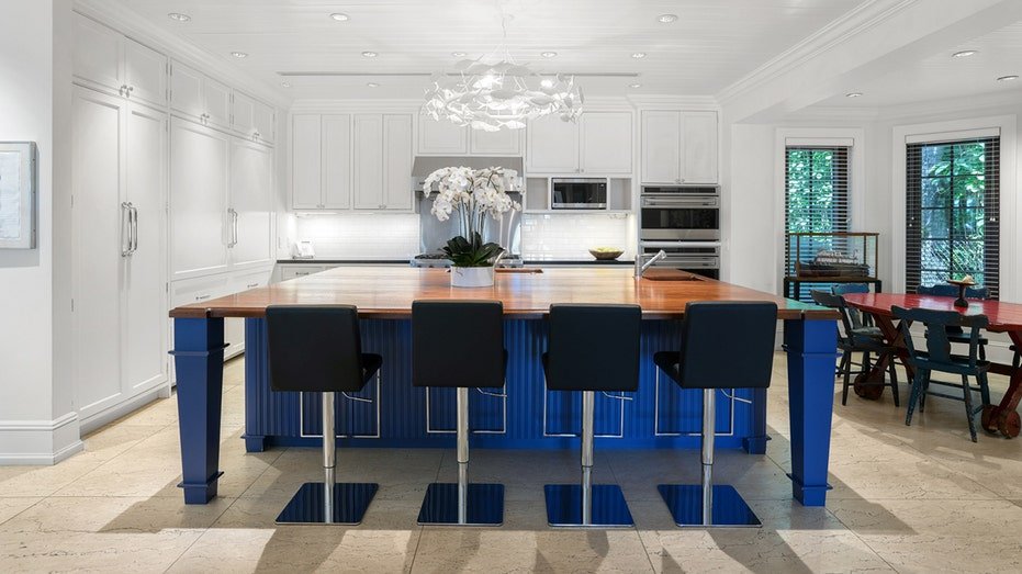 The kitchen features a large island to eat in the middle and an informal dining area.
