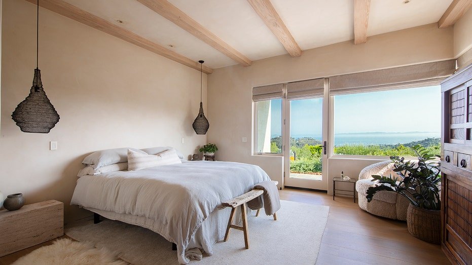 The basic bedroom features exposed wooden symptoms on the ceiling and reaching the yard.