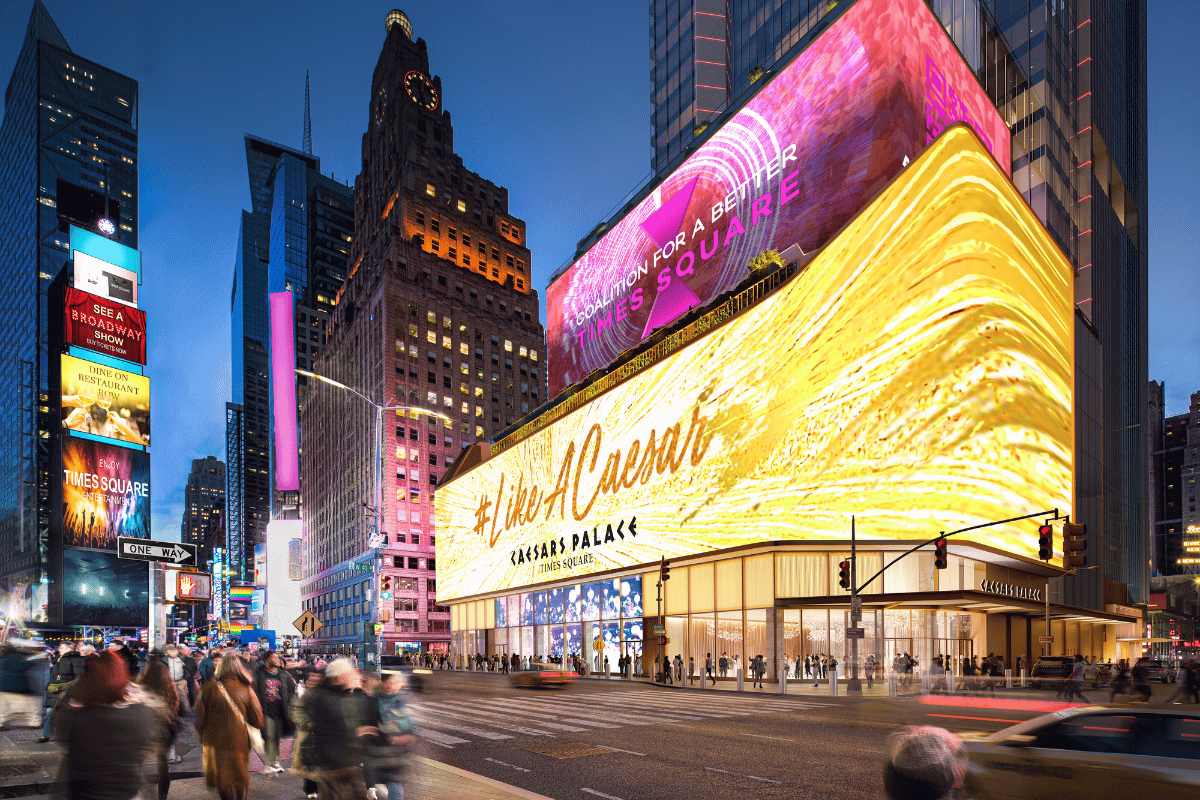 Presenting the proposed Caesars Times Square with large luminous signs and crowds walking in the famous New York City area at night.