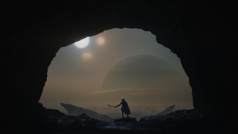 Yautja holds a silhouette through a cave on a remote planet in the predator: Badlands