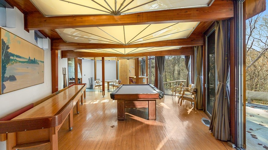 Games room with a billiard and shuffleboard table.
