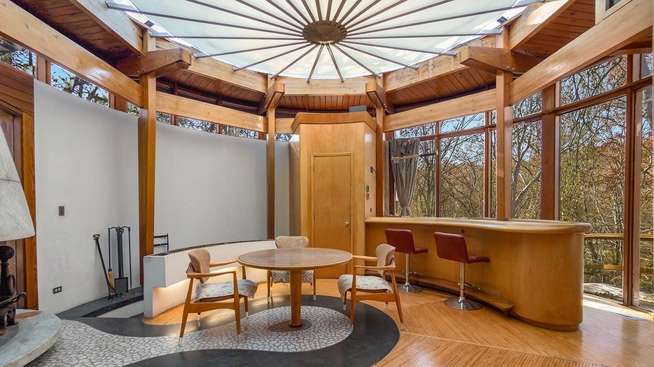 The office features a circular roof and wooden furniture.