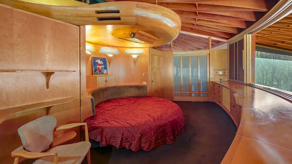 The circular bedroom has wooden beams on the ceiling.