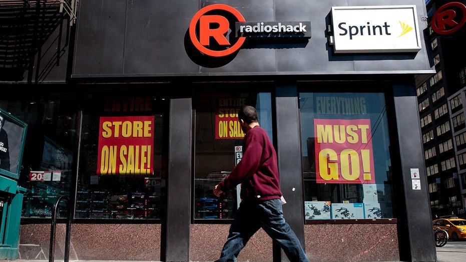A man walks through the front of the Radioshack store in New York City.
