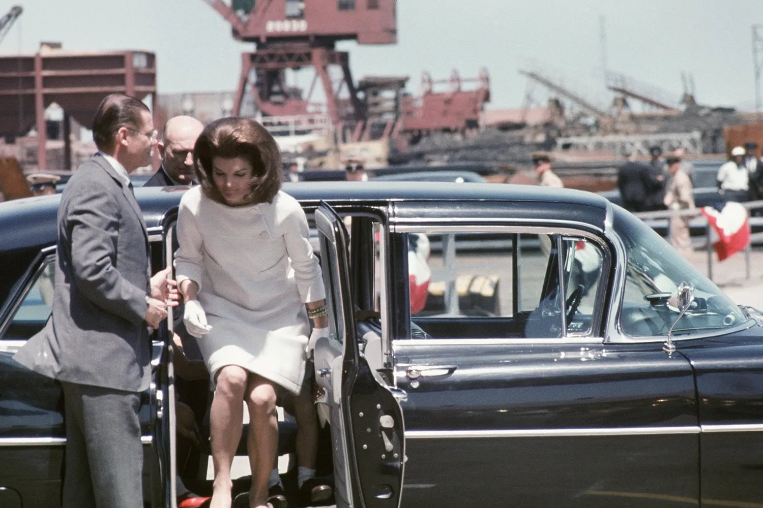 Secretary of Defense Robert McNamara helps former First Lady Jacqueline Kennedy out of her car before a ceremony to christen the USS John F. Kennedy on May 27, 1967, in Newport News, Virginia.