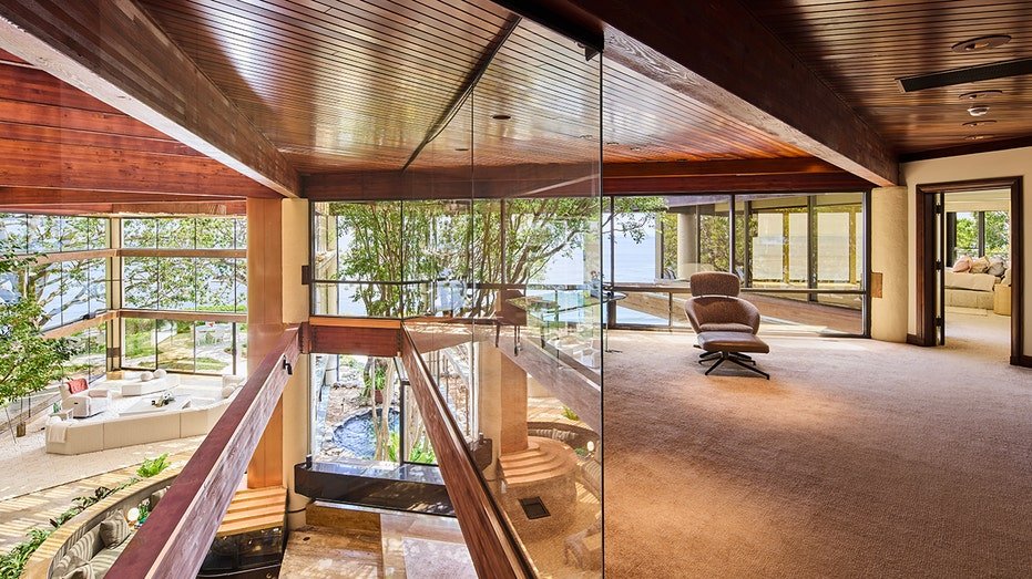 The office is located at the upper level with glass windows, which gives the illusion that it is floating.