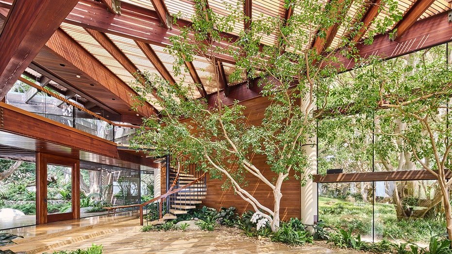 The entrance is characterized by a stairs that lead to higher levels as well as glass windows from floor to ceiling.