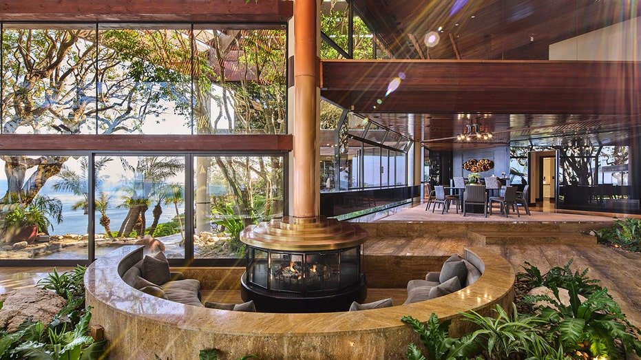 The living room features a fireplace with circular seats around it.