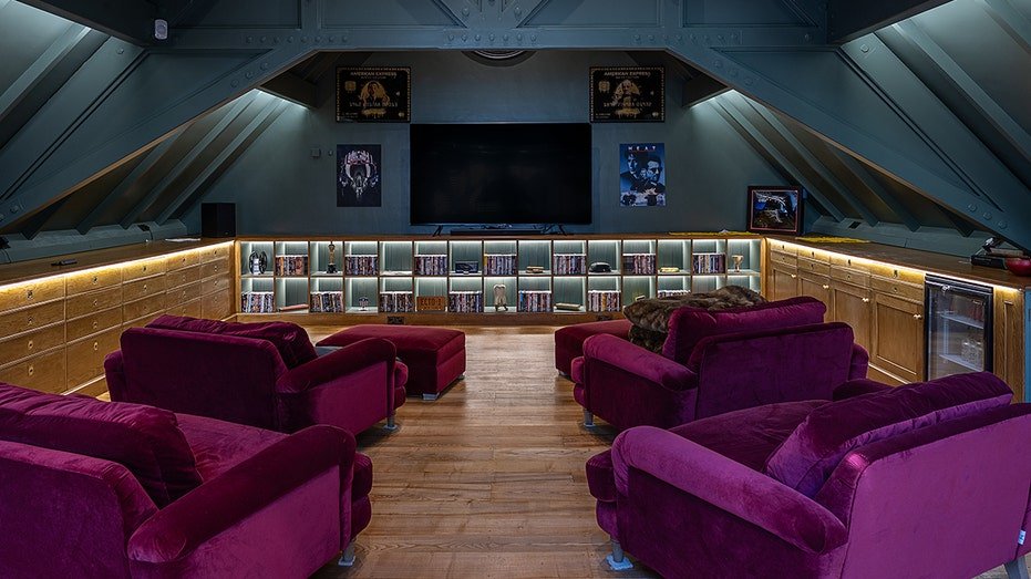 The house also includes a cinematic room with purple chairs and a large TV.